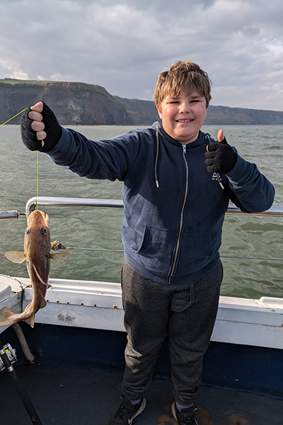 A happy passenger showing the fish they caught